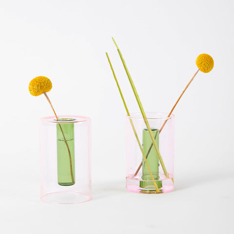Reversible glass vase in pink and green styled with an orange flower.