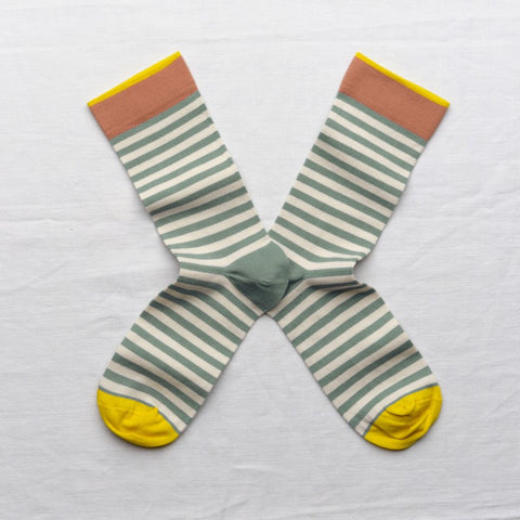 A pair of blue striped socks with red and yellow trims. 