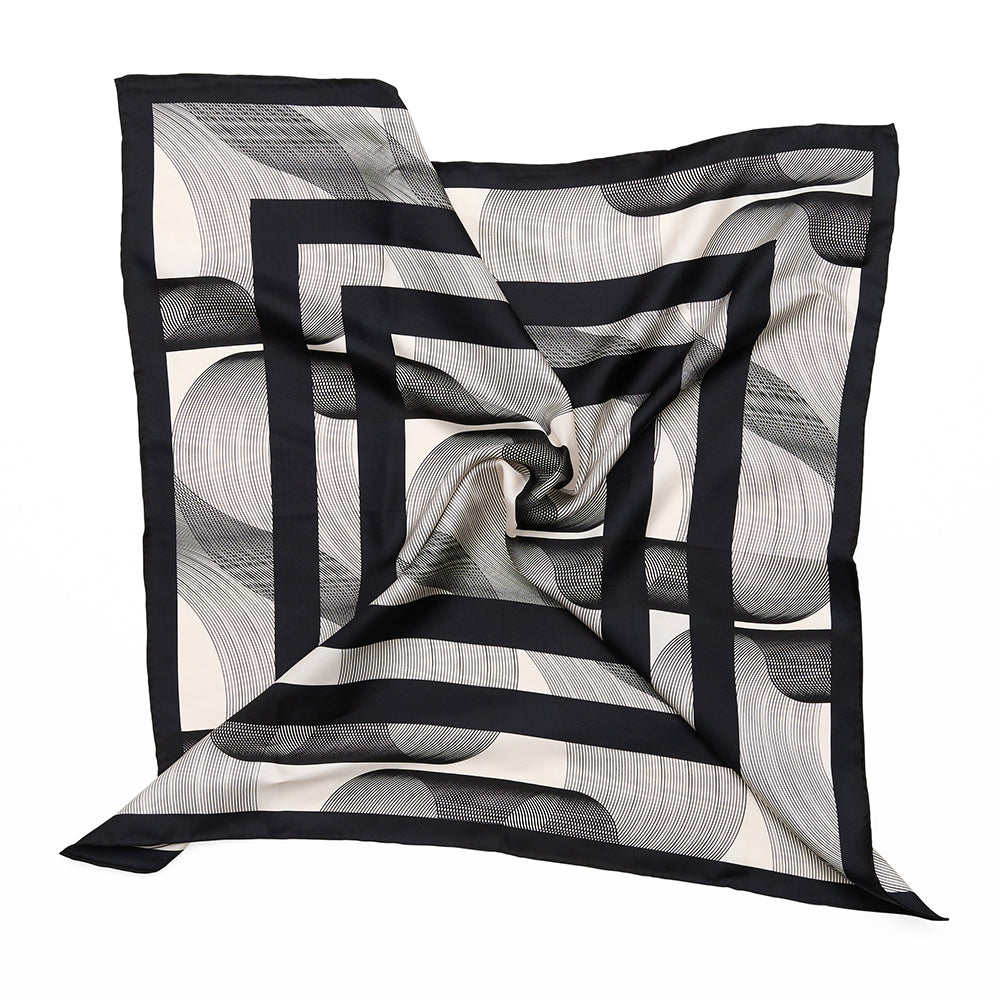 A styled monochrome scarf with geometric stripes and swirled shapes.