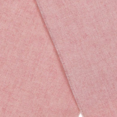 A close up view of the wool texture of a scarf in pale pink.