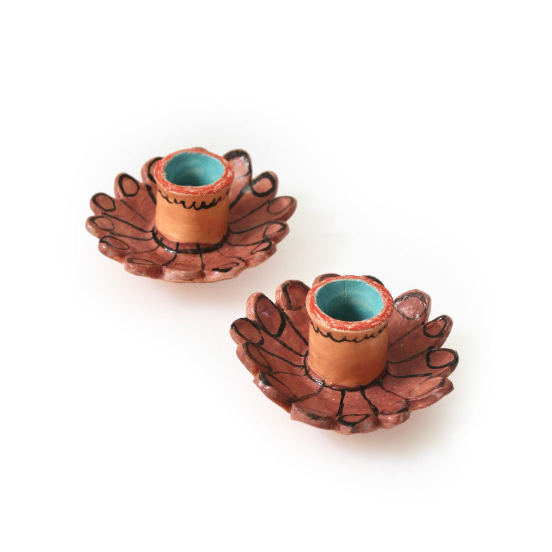 Pair of short, hand painted candlestick holders with a flower base in rust red.