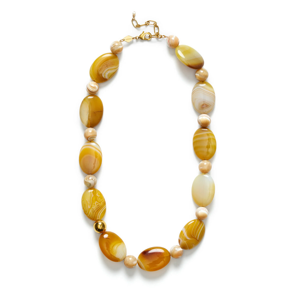 Chunky beaded necklace in butterscotch brown on a gold chain against a white background