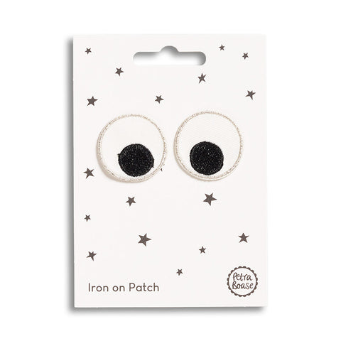 An iron on patch featuring a pair of googly cartoon eyes.