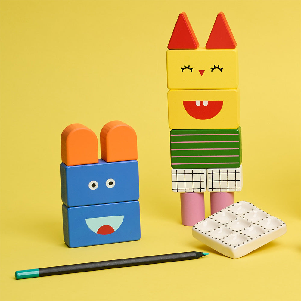 Colorful toy blocks assembled into a character on a yellow background