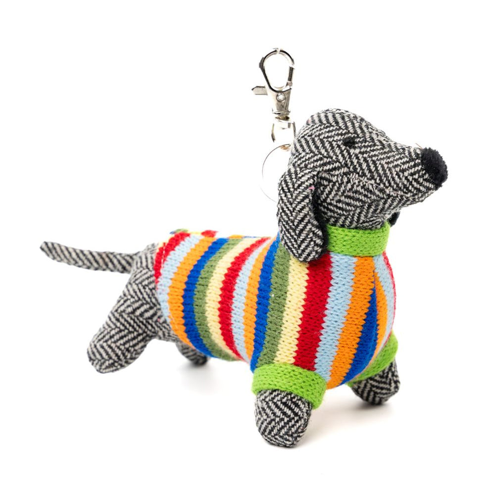 Stuffed dog toy with a colourful striped body and tweed herringbone fabric on a white background