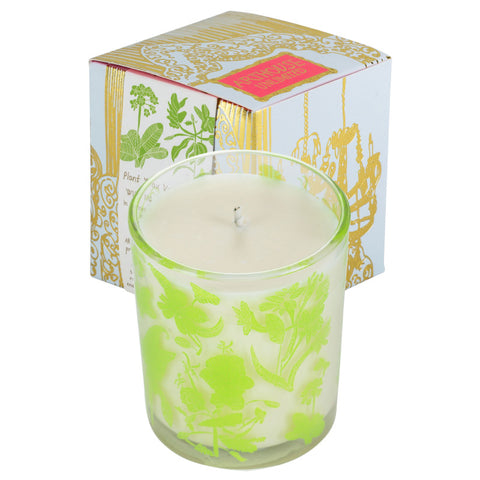 Glass candle with bright green floral and plant designs on the outside of it.