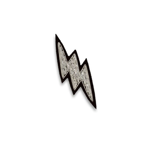 Silver lightning bolt shaped embroidered brooch.