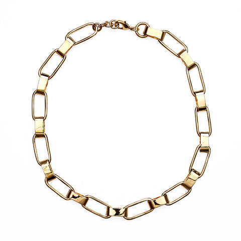 Chunky gold chain necklace against white background.