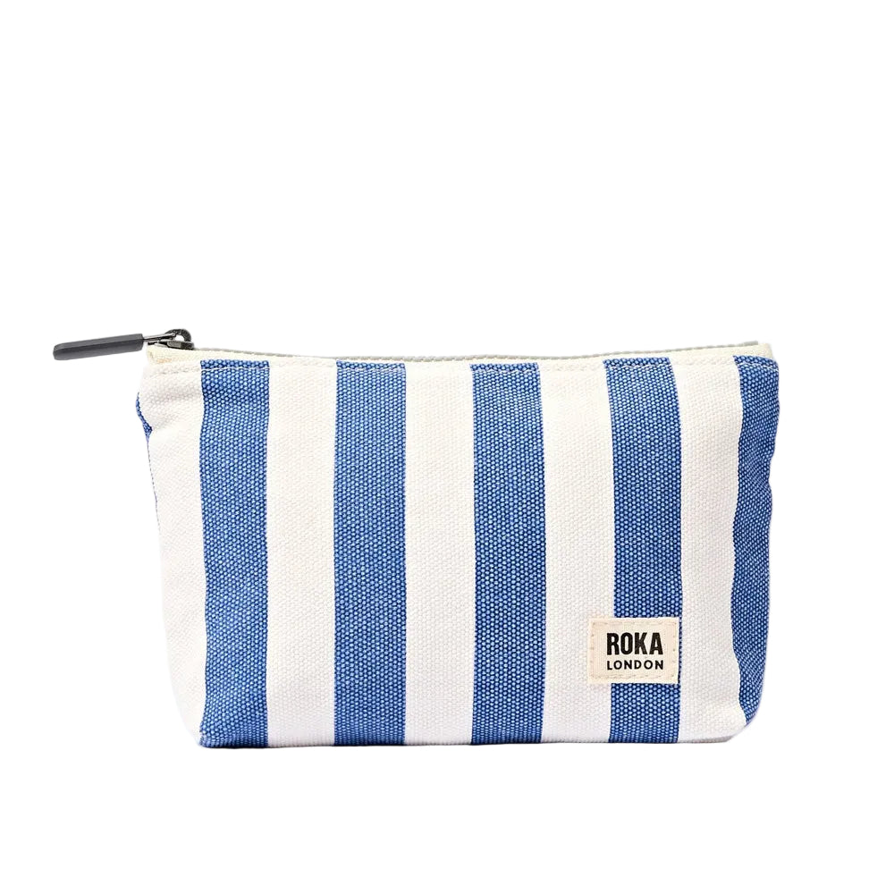 A rectangular zippered pouch with vertical blue and off white stripes, featuring a small white brand label that reads 'roka london' on the lower right side.