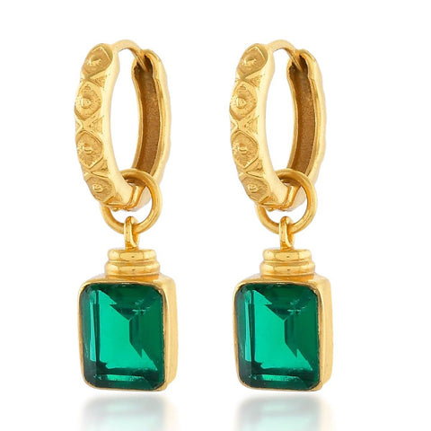 Margot earrings with an emerald green square crystal hanging from a gold hoop.