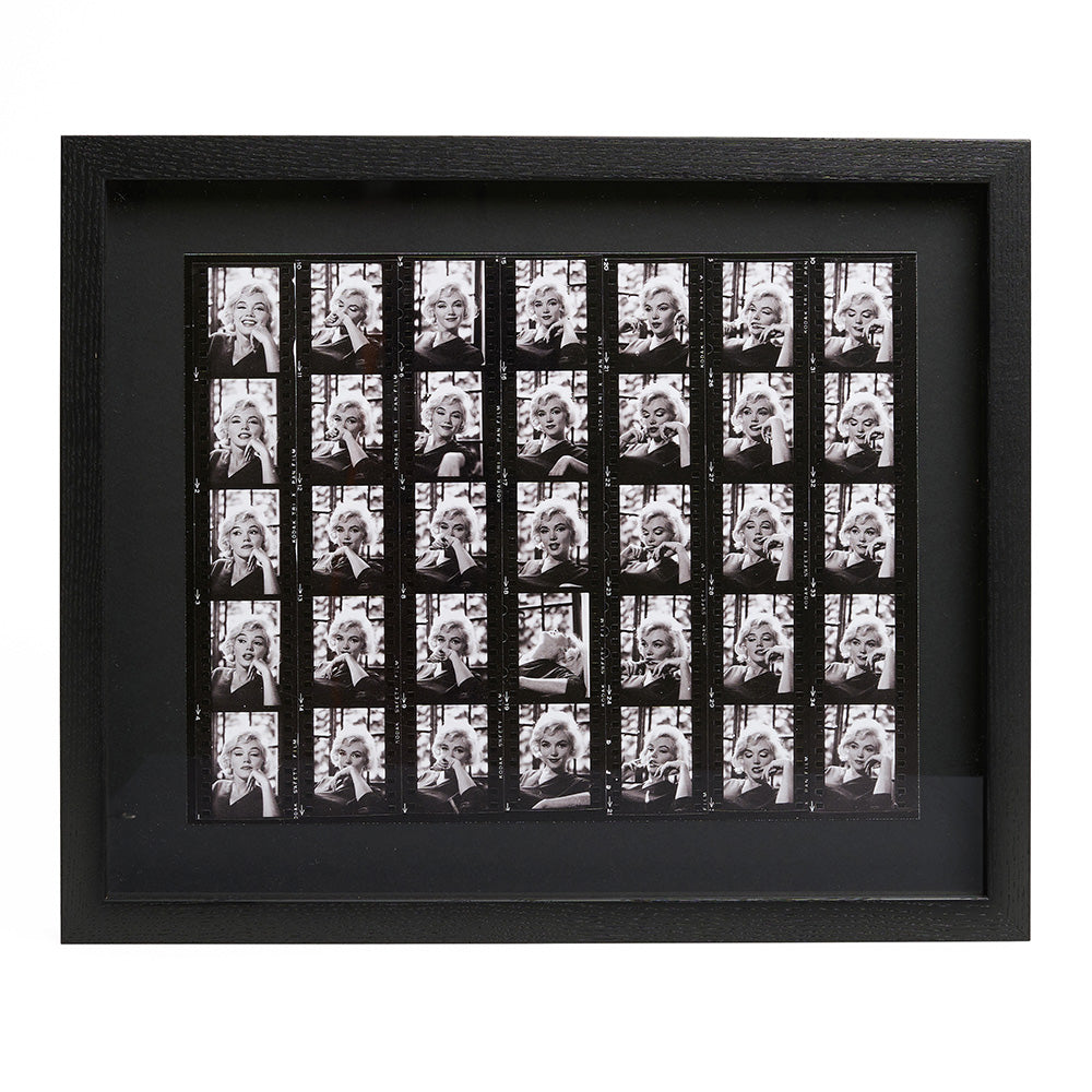 Black and white contact sheet photographic print in a black frame.
