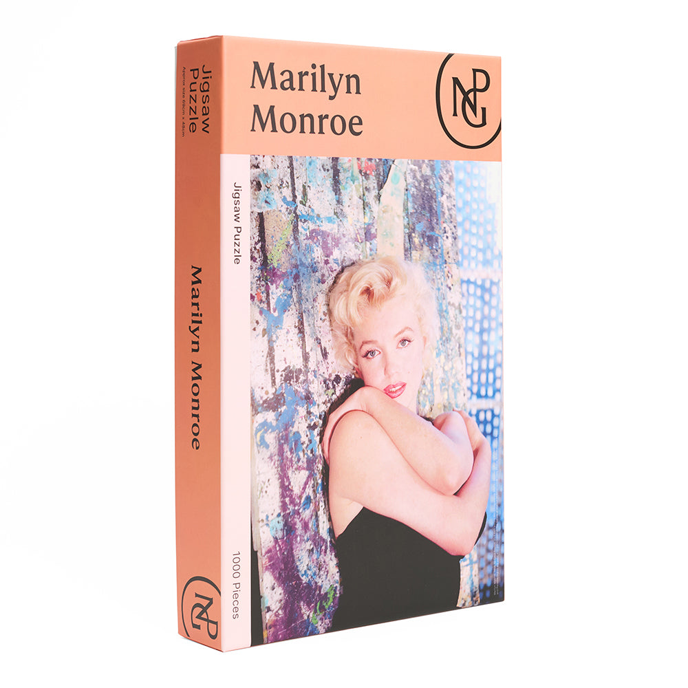 Side view of boxed jigsaw puzzle with a photograph of a marilyn monroe against a curtain.