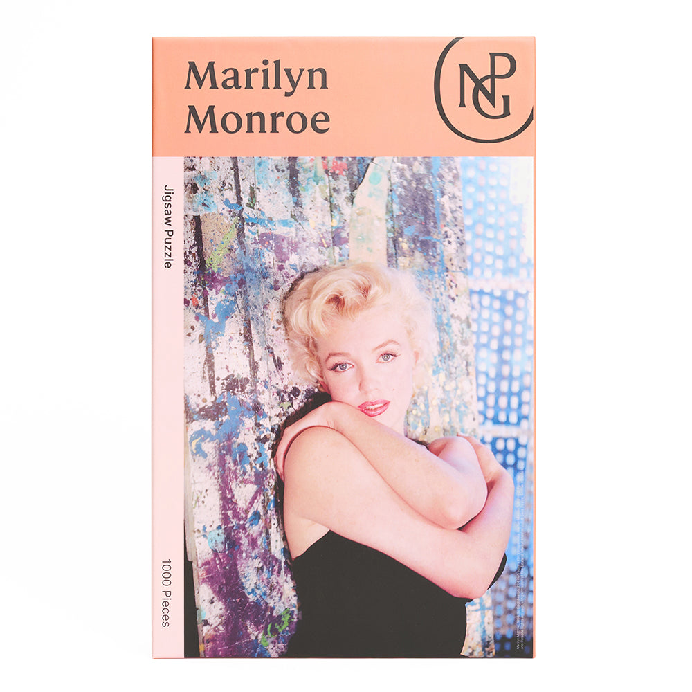 Boxed jigsaw puzzle with a photograph of a marilyn monroe against a curtain.