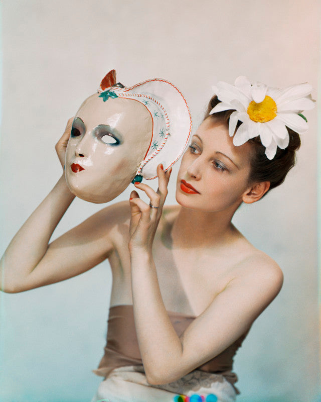 Limited edition print featuring yevonde's photograph of rosemary chance holding a mask and wearing a large daisy on her head.
