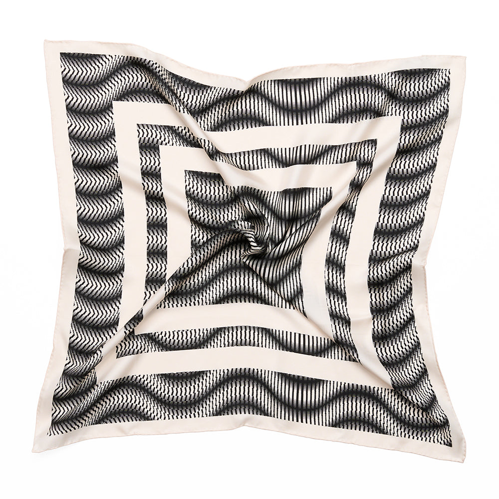 A styled monochrome square scarf with geometric white shapes and black swirls.