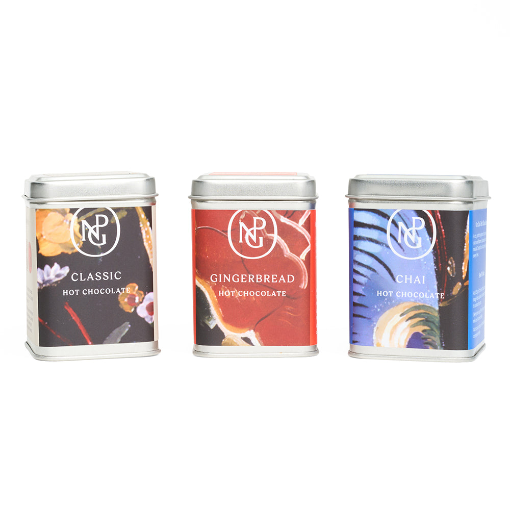Three tins of hot chocolate with different flavors on a white background