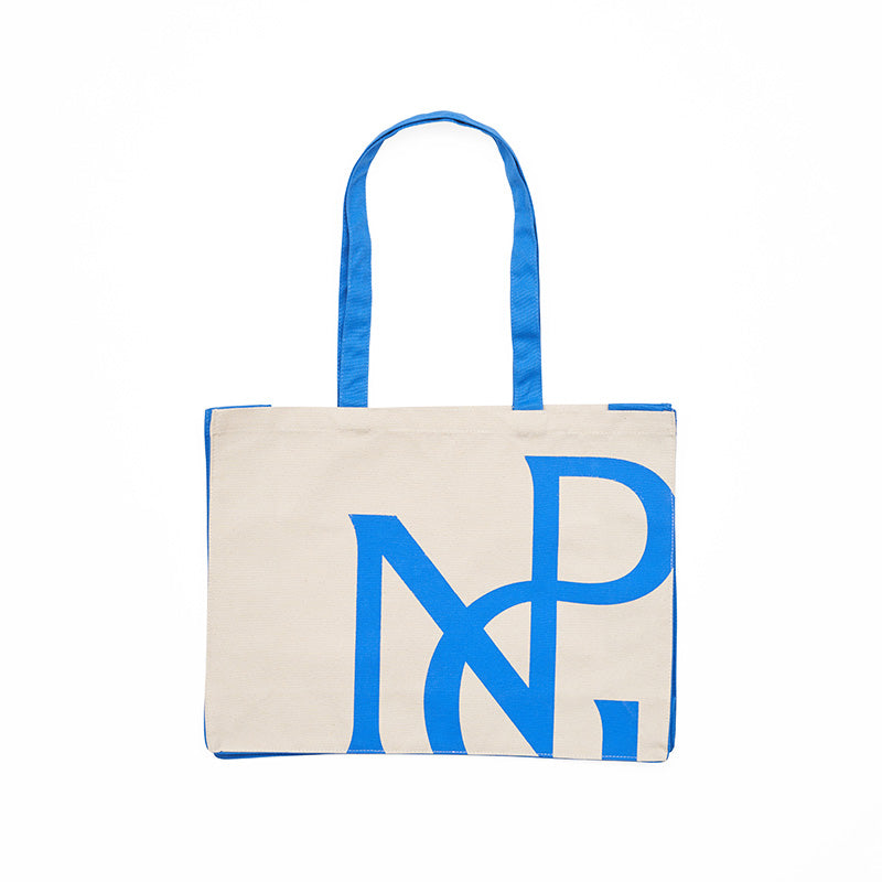 Front view of a wide cream tote bag with blue sides and handles and npg monogram design in blue.