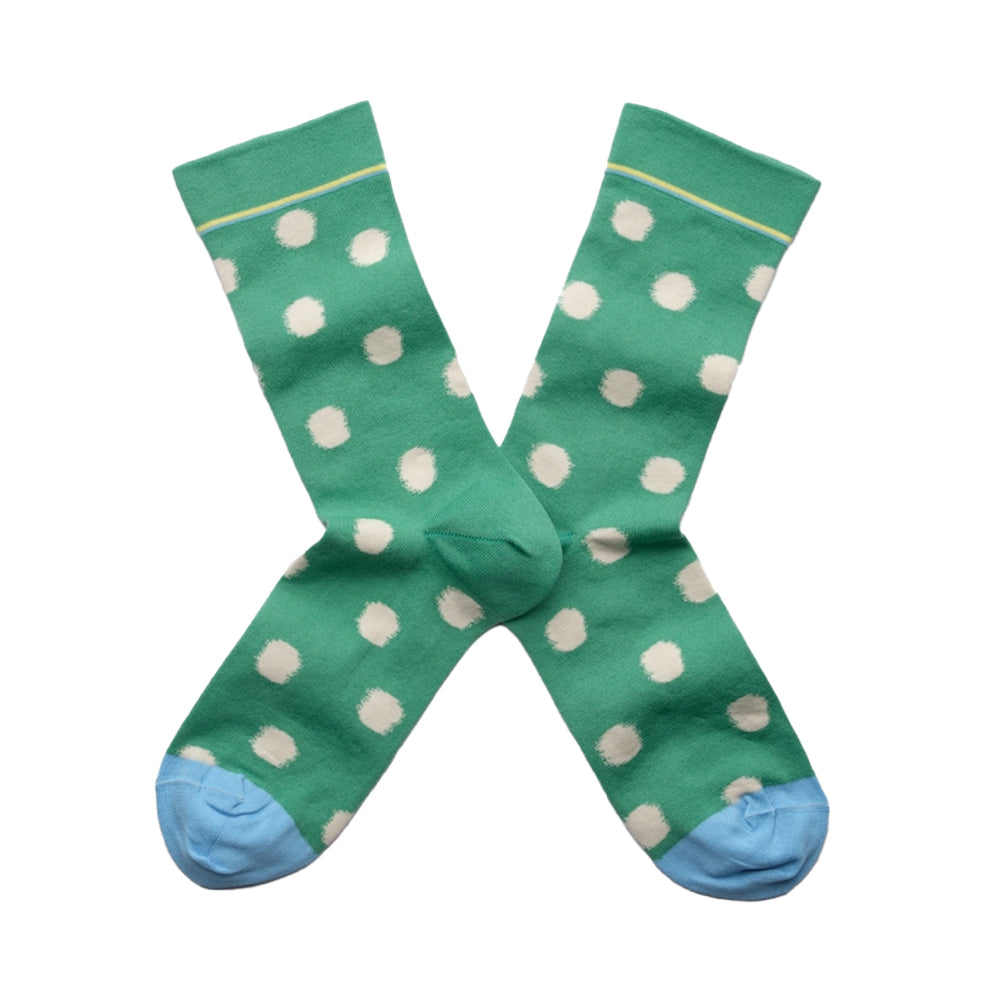 Green socks with white polka dots on a white background