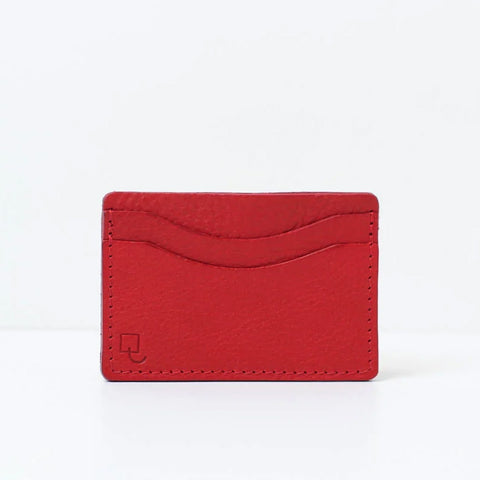 Rectangular red leather card holder with two card compartments. 