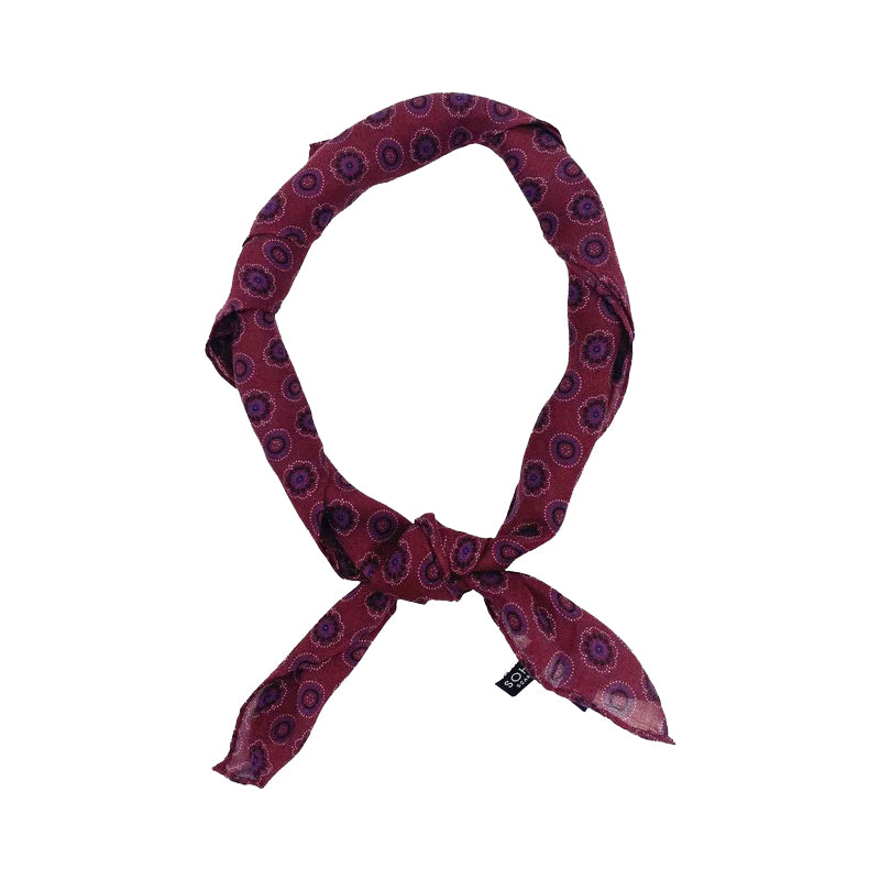 A burgundy geometric bandana tied in a knot.