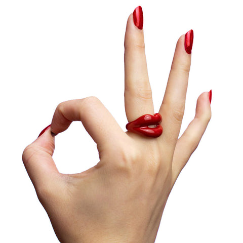 Hotlips ring in classic red on the middle finger of a hand
