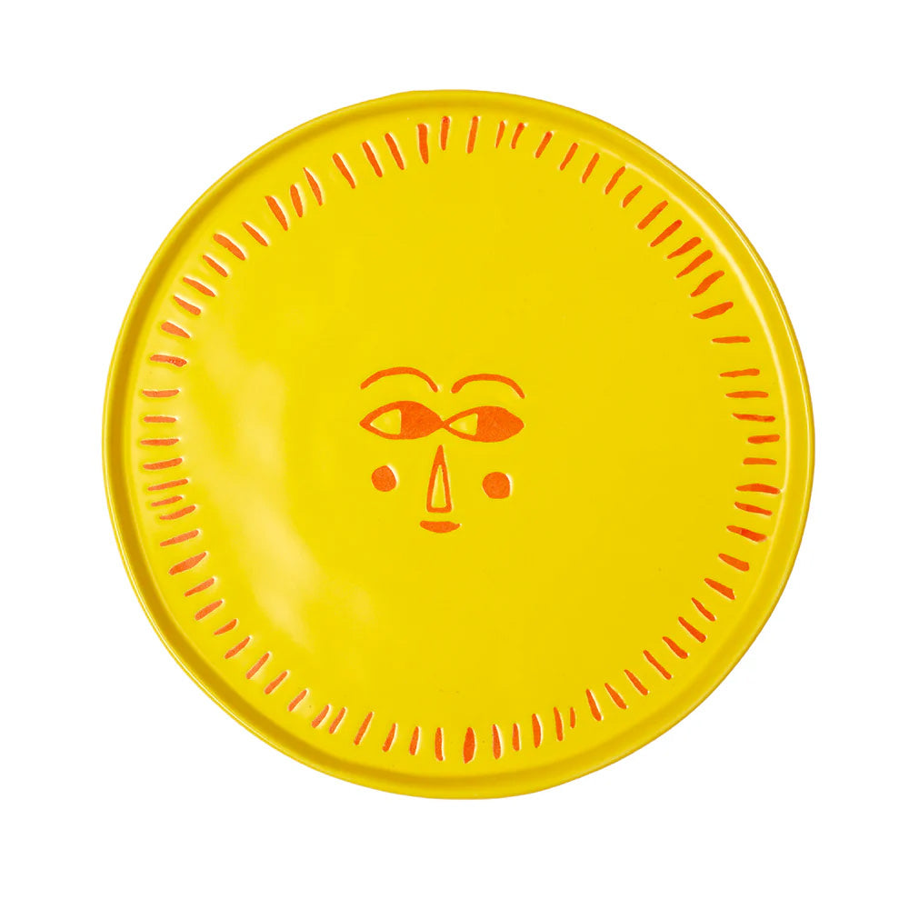 Yellow plate with a sunshine face design on a white background