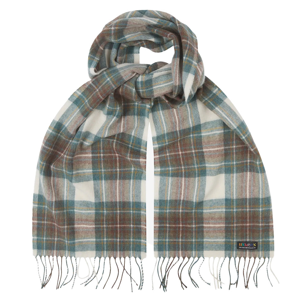 A styled scarf in green and beige tartan pattern with tassels.