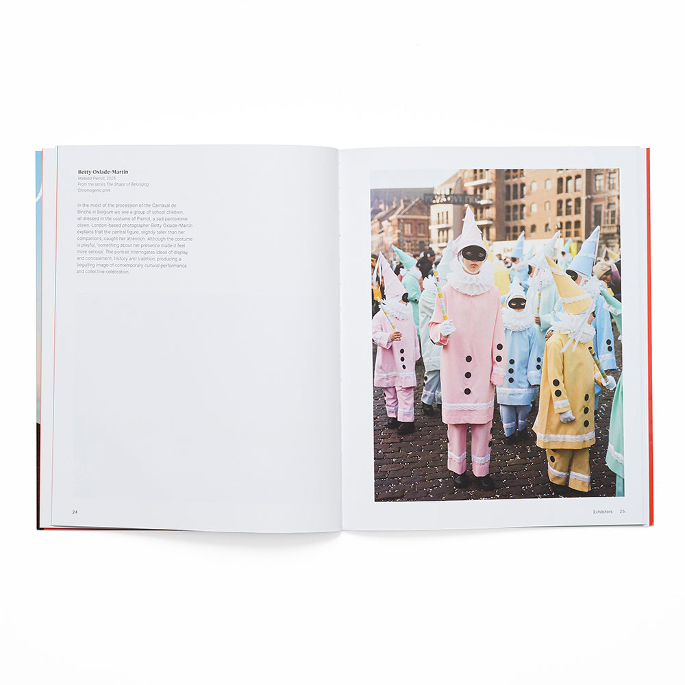 Open book showing a photo of people in colorful costumes on a white background