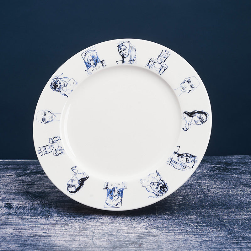 White ceramic plate with a series of painted portraits in blue around the outside.