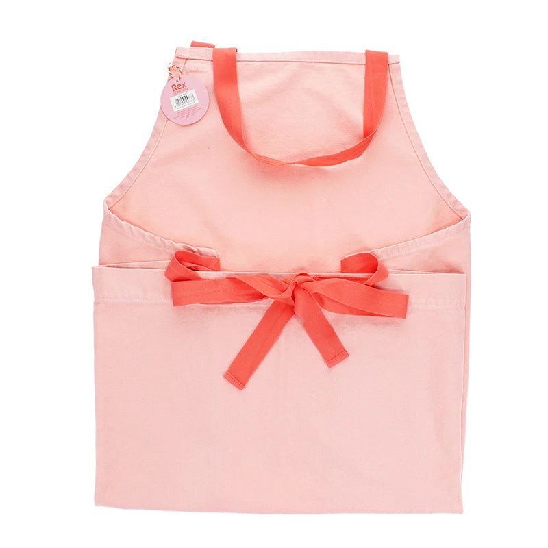 Reverse of light pink apron with contrasting deep pink waist tie tied in to a bow.