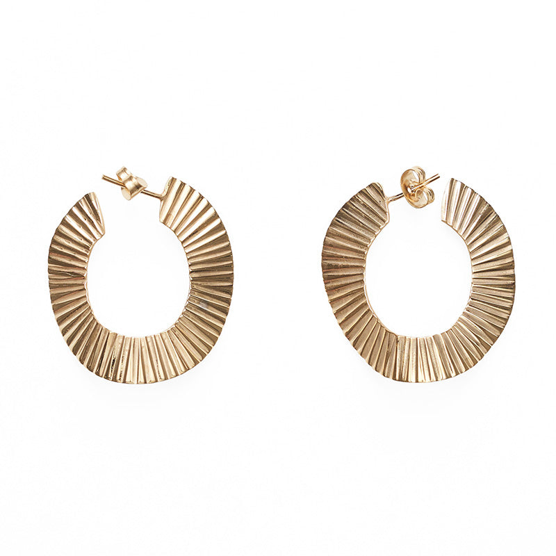 A pair of gold metal round textured earrings.