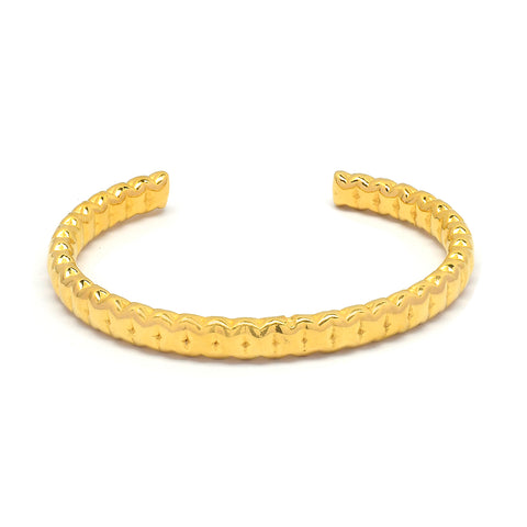 Chunky gold bangle with textured detailing. 