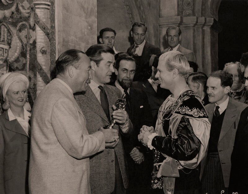 Hal wallis and ray milland present laurence olivier with the academy award for 'henry v' on the set of 'hamlet' npg x137986