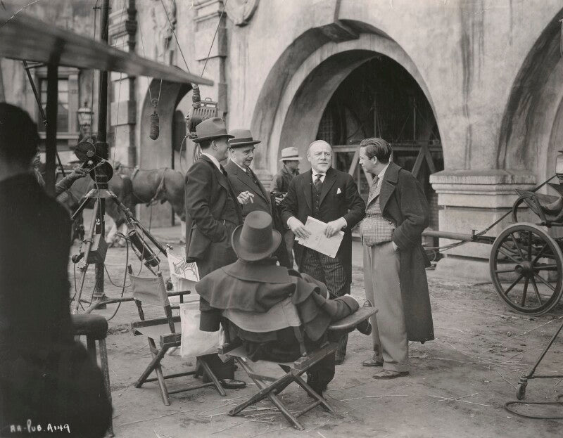 Jack warner (horace john waters), h.g. wells, fredric march (ernest frederick mcintyre bickel), edmund gwenn and mervyn leroy on the set of 'anthony adverse' npg x198472