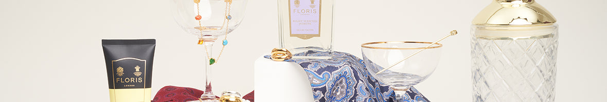 Luxury christmas gifts featuring candle against red background.