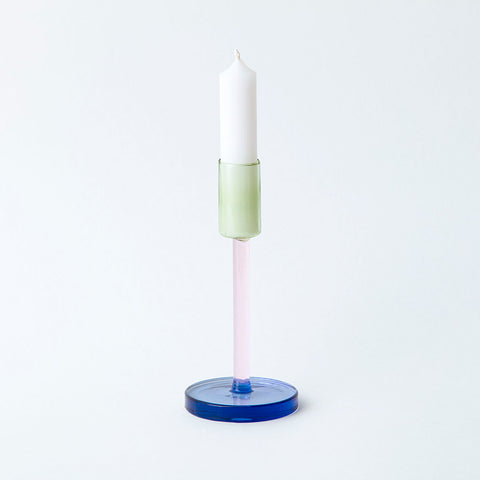 Tall glass candlestick holder in green, pink and blue colour block sections.
