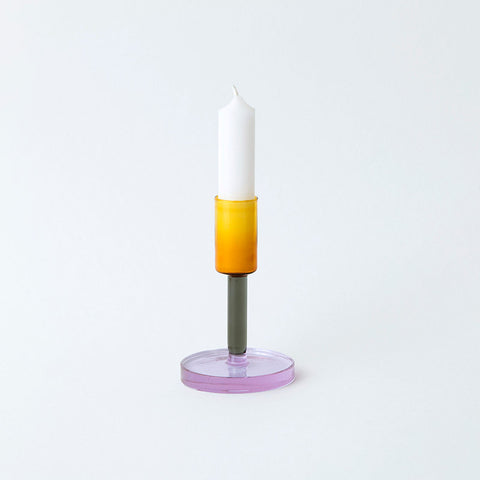 Glass candlestick holder in orange, grey and purple block colour sections.