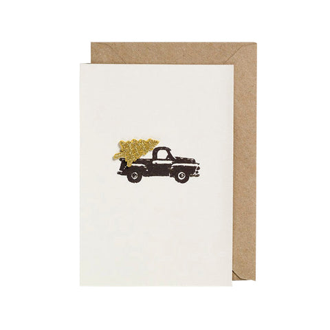 A Christmas card featuring a car with a tree, which is an iron-on patch