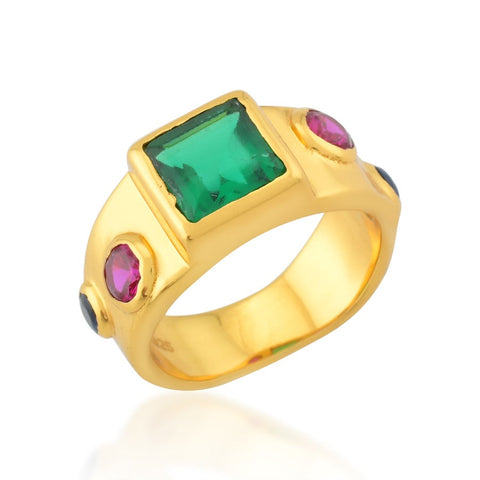 A gold band ring with large central green crystal surrounded by smaller blue and magenta crystals.