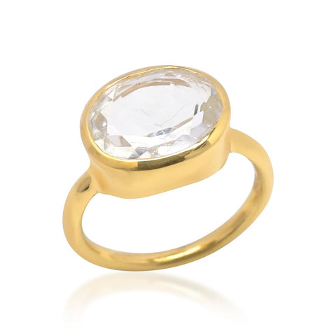 A gold band ring with a large clear crystal in the centre.
