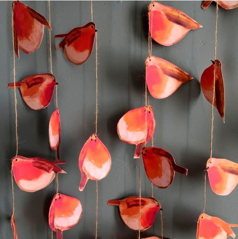 Red robins on a garland hanging in rows. 