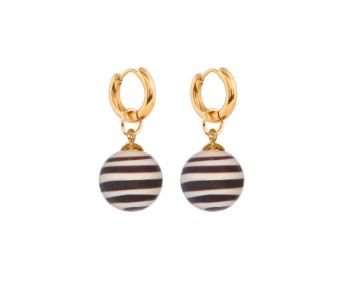 A pair of gold plated hoops each holding a black and white ball shaped pendant. 