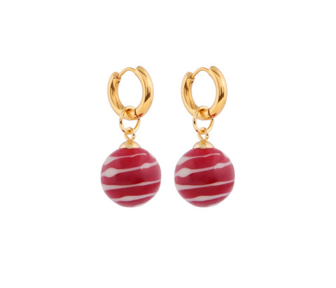 A pair of gold plated hoops each holding a red and white ball shaped pendant. 