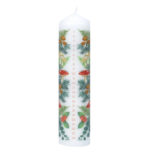 A tall candle with forestry decorations and the numbers 1-24 listed vertically down the candle. 