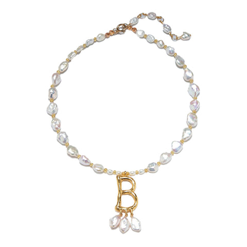 A pearl necklace on a gold chain with gold 'B' pendant and three single hanging pearls underneath. 