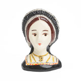 An egg cup featuring a bust of Anne Boleyn in black regal clothing and gold b necklace. 
