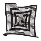 A styled monochrome scarf with geometric stripes and swirled shapes. 