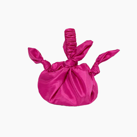 A pink cerise bag formed from tied knots of satin fabric and a scrunchie style handle.