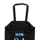 Interior view of a zipped pocket inside of a black tote bag with handle. 