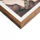 Close-up of a wooden picture frame corner with a portion of a painting visible.
